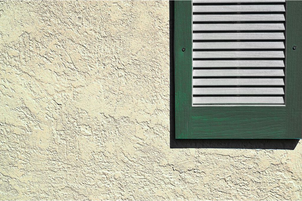 stucco wall exterior with green shutter